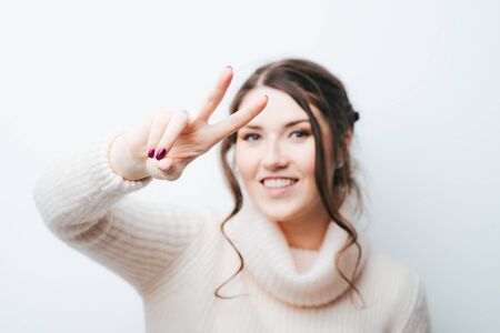 on a white background girl showing two fingersの写真素材