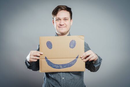 Man with the painted happy smile on the sheet of paperの写真素材