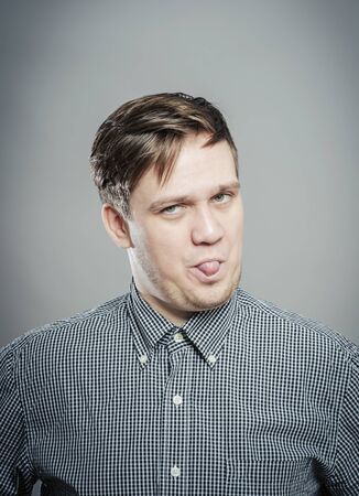 Adult man with bad manners - showing his tongueの写真素材