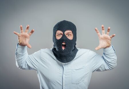 Face of a angry burglar wearing a black ski mask or balaclava
