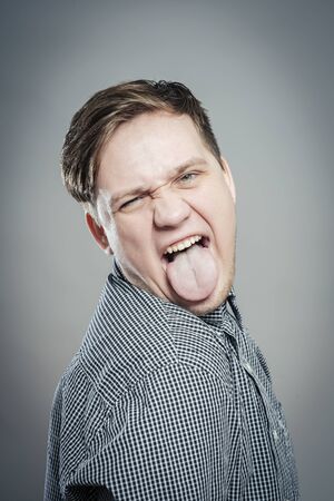 portrait of a young man showing his tongueの写真素材