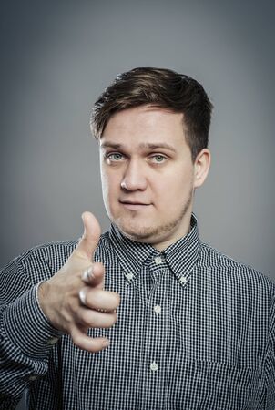 young  man pointing at someone gesture with fingerの写真素材