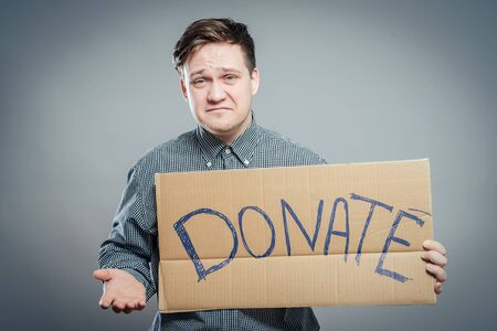 young man showing board with text: Donateの写真素材