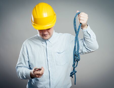 Construction worker holds a rope and carbine. Full length studio shot isolated .