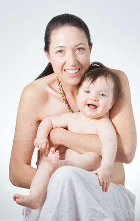 A young mother holds her joyful babyの写真素材