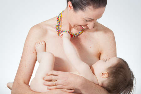 A young mother holds her breast feeding babyの写真素材