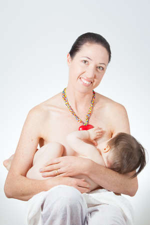 A young mother holds her breast feeding babyの写真素材