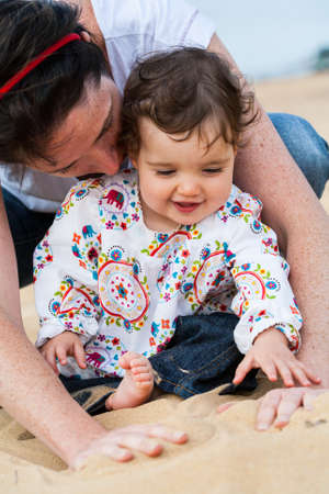 An infant and Mummy enjoy a special moment at the beachの写真素材