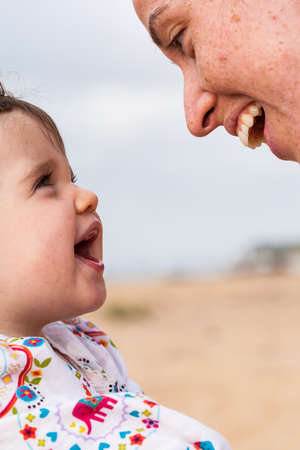 An infant and Mummy enjoy a special moment at the beachの写真素材