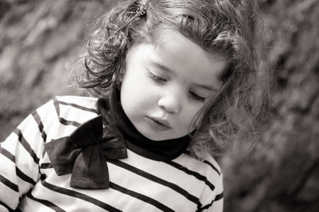 A child looks pensive outdoorsの写真素材