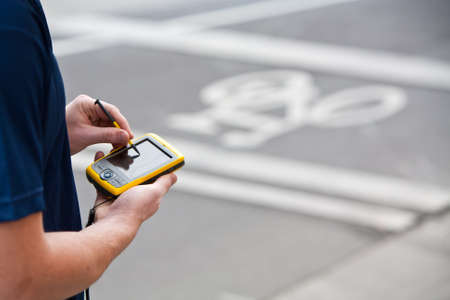 A man uses a handheld GPS unit to navigateの写真素材