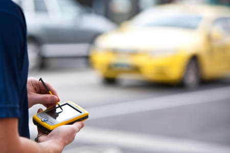 A man uses a handheld GPS unit to navigateの写真素材