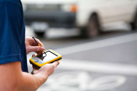 A man uses a handheld GPS unit to navigateの写真素材