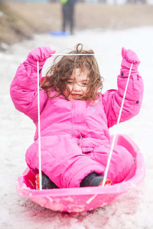 A young girl tobogganing at Lake Mountain in Victoria, Australiaの写真素材