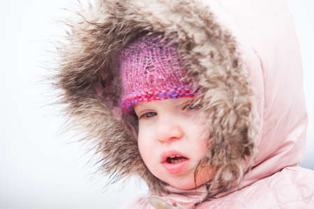 A toddler is wrapped up warm in the cold wintery conditions at Lake Mountain in Victoria, Australiaの写真素材