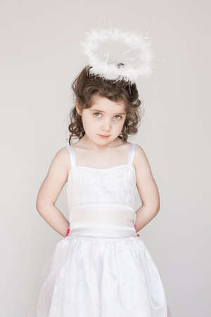 A little girl enjoying her angel halo and outfit at Christmasの写真素材