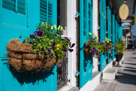 Flowers in baskets hang off shutter doors during Mardi Gras in New Orleans, Louisiana, USAの写真素材