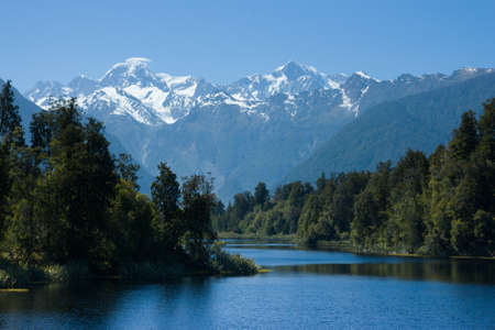 Mt Cook overlooks Lake Matheson on a clear winter's morning in New Zealandの写真素材