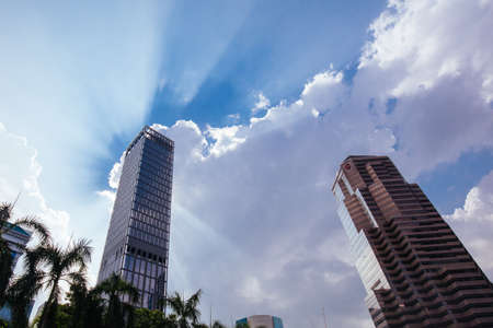 A skyscraper in Kuala Lumpur stands tall in front of a cloudy silver lining in Kuala Lumpur,...