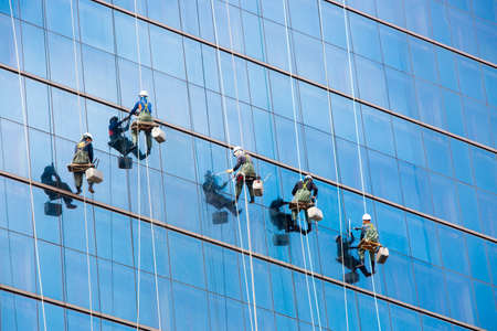 Seoul, South Korea - October 25, 2014: Laborers clean windows as a team on a skyscraper in downtown...