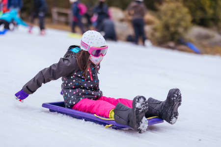 Young Girl Tobogganing in Australiaの写真素材