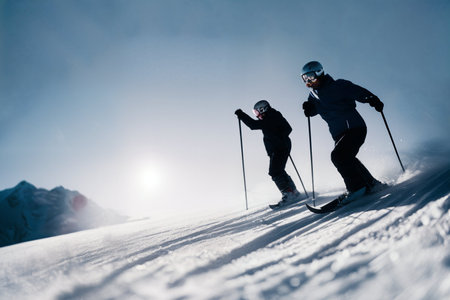 Two skiers cross-country skiing in the mountains at sunset. AI Generated.の素材