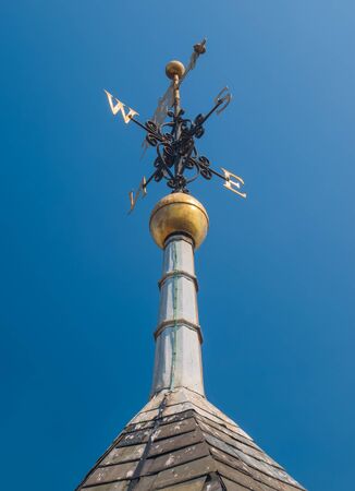 wind-cock with cardinal marks on top of spireの写真素材