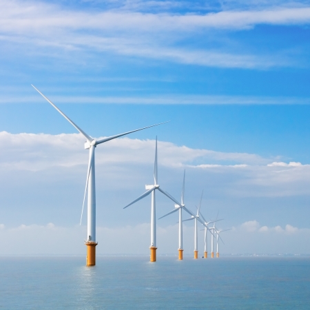 wind power generators farm at sea with white clouds and blue skyの写真素材