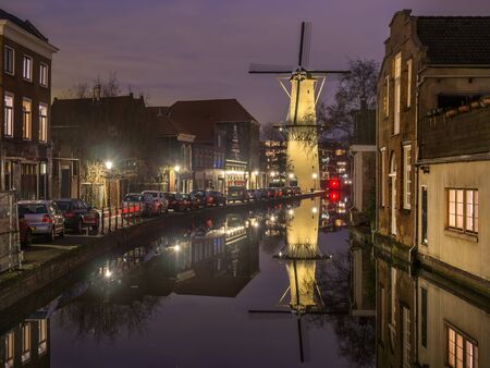Old Dutch city Schiedam landscape during calm weather with reflections in a canal and old windmillの写真素材