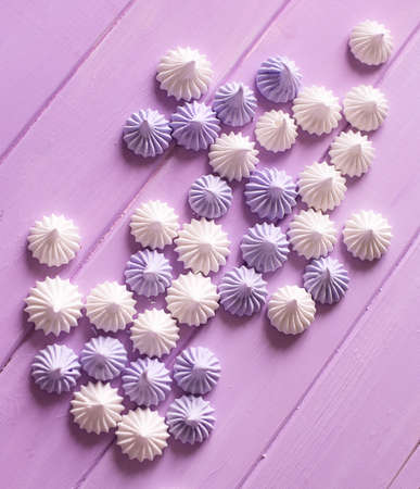 Colored meringue kisses on wooden tableの写真素材