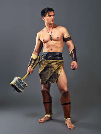 Muscular man in the image of ancient warrior on a gray backgroundの写真素材