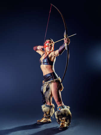 A young girl in image Northern warrior woman shoots an arrow