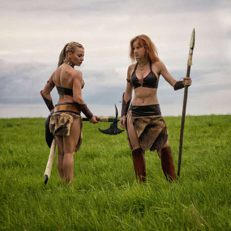 Beautiful athletic woman and girl  in the image of an ancient barbarian warrior on summer nature background.の写真素材