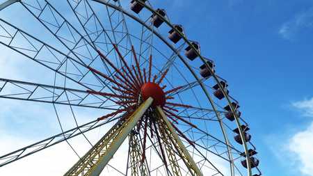 Ferris wheel against the blue sky with cloudsの写真素材