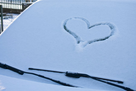 A heart drawn in the snow on the windshield of a car. Close up.の写真素材