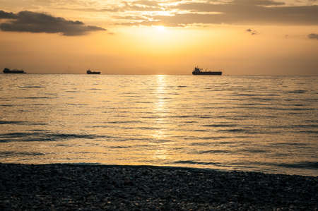 Beautiful orange sunset over the sea, landscape with ships and beachの写真素材