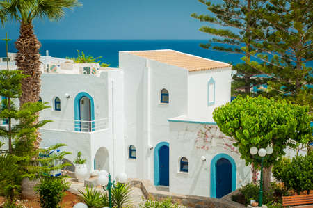 Greek architecture - white buildings, sea and blue windows, Bougainvillea on the wallの写真素材