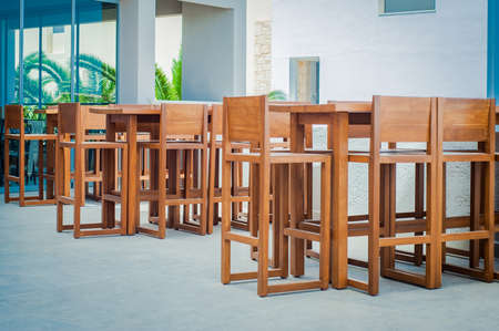 Wooden tables and chairs in seaside restaurantの写真素材