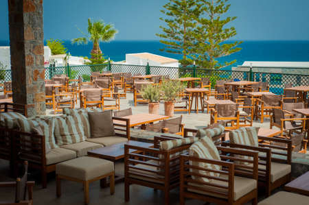 Wooden tables and chairs in seaside restaurantの写真素材