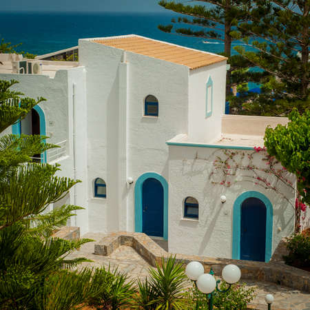 Greek architecture - white buildings, sea and blue windows, Bougainvillea on the wallの写真素材