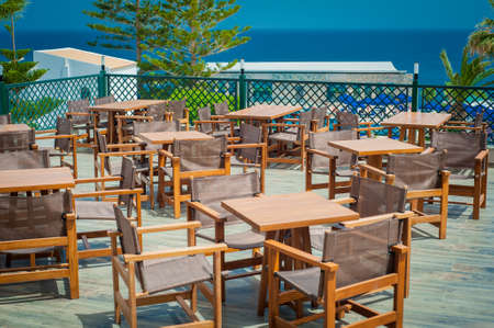 Wooden tables and chairs in seaside restaurantの写真素材