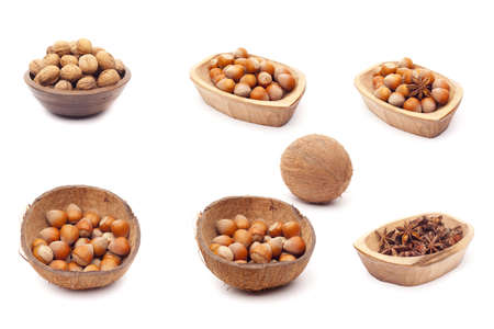Nut collection of walnut, hazelnut, mag nut in rustic wooden bowls coco bowls, isolated over white...