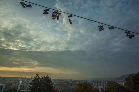 Shoes on a wire at the Prague Metronome, Czech Republicの写真素材