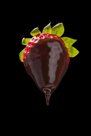 strawberry in chocolate on black isolateの写真素材