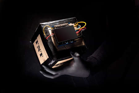 Terrorist is holding home made bomb with cables and remote controled detonator. Preparation for terrorist acts.の写真素材