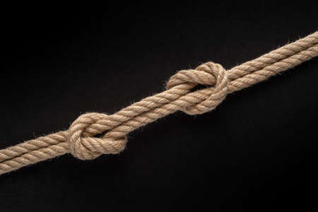 Fishing node on black background. Nautical rope knot