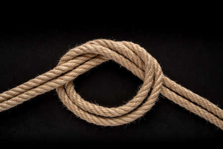 Overhand Bow Knot on black background. Rope node