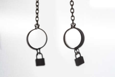 Silhouette of the retro handcuff with lock hang on the white backgroundの写真素材