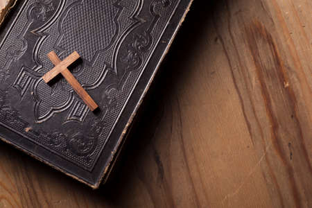Old holy bible with wooden Christian cross