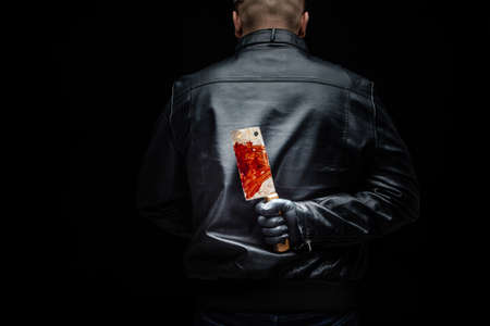 Serial killer maniac holding killer tools behind his backの写真素材